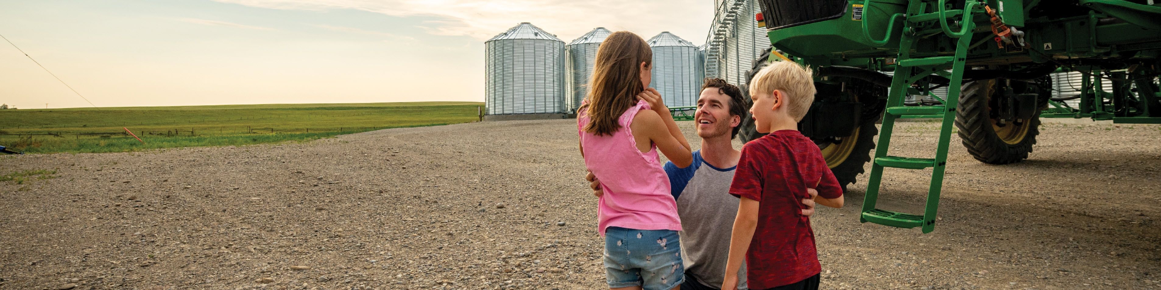 Grower and children standing in front of a tractor