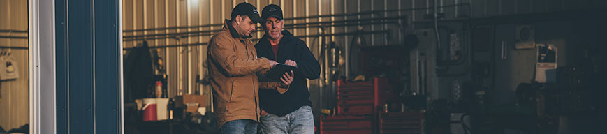Two male farmers looking at tablet