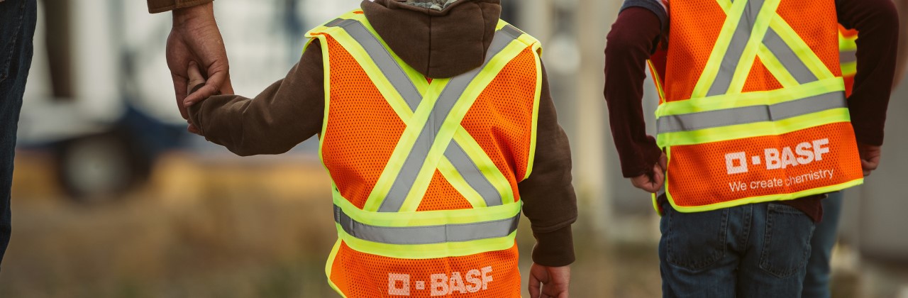 Children wearing orange safety vests walking
